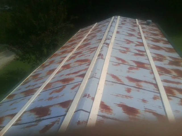 Rusted metal roof panels with new wood purlins before replacement — Storm Damage Roof Repair in Sedalia by Roofing Brothers